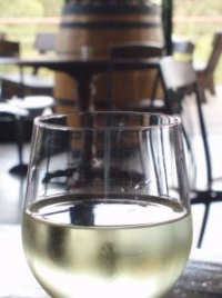 Bicchiere di vino in primo piano e botte nello sfondo